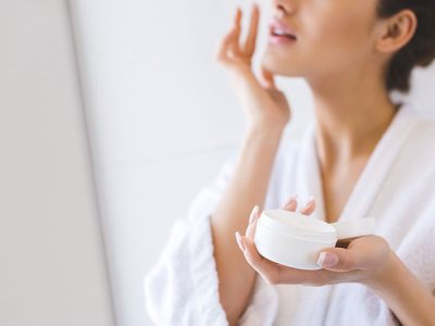 cropped-shot-of-beautiful-woman-in-bathrobe-applyi-GS438GG.jpg